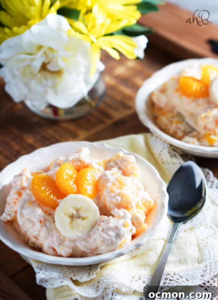 A bowl of creamy Orange Dream Salad with a serving spoon, ready to be enjoyed.