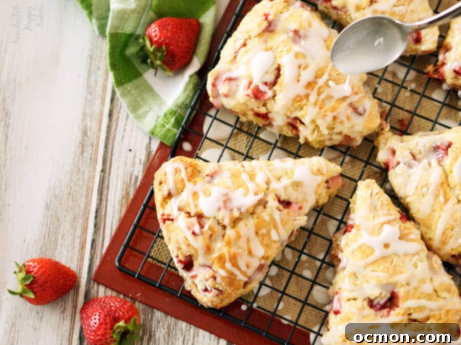 Drizzling lemon glaze over strawberry scones. 