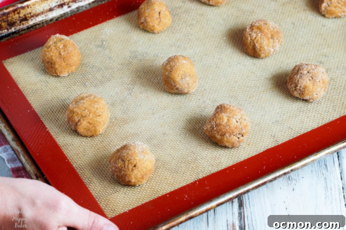 A sheet pan filled with perfectly spaced pumpkin gingersnap cookies, ready for baking in the oven.