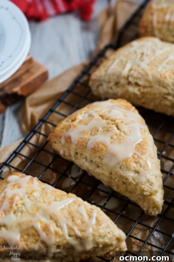 Delicious freshly baked Eggnog Scones cooling on a wire rack, drizzled with a creamy eggnog glaze and sprinkled with nutmeg