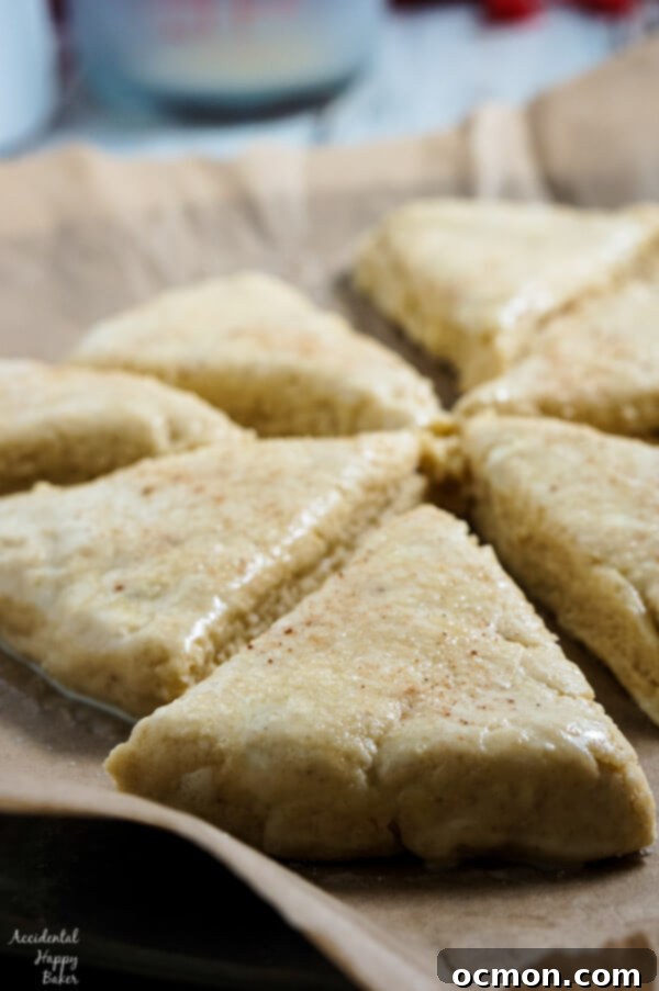 Hands cutting cold butter into a bowl of dry ingredients for Eggnog Scones, showing the crumbly texture