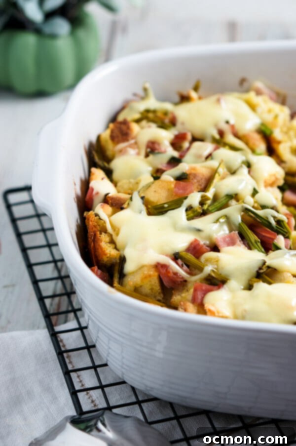 Spring Ham and Asparagus Bake 2 Layers of English muffins, ham, asparagus and cheese are drenched in eggs, Hollandaise mix and half and half for a hearty breakfast casserole that works great anytime of year. #ham #asparagus #breakfastcasserole #breakfastrecipe #accidentalhappybaker