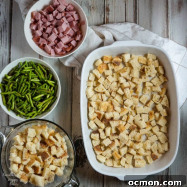 Spring Ham and Asparagus Bake 3 Layers of English muffins, ham, asparagus and cheese are drenched in eggs, Hollandaise mix and half and half for a hearty breakfast casserole that works great anytime of year. #ham #asparagus #breakfastcasserole #breakfastrecipe #accidentalhappybaker