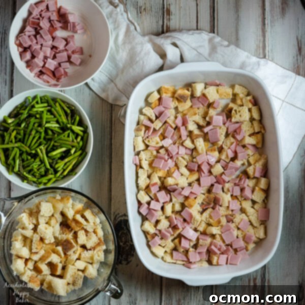 Spring Ham and Asparagus Bake 4 Layers of English muffins, ham, asparagus and cheese are drenched in eggs, Hollandaise mix and half and half for a hearty breakfast casserole that works great anytime of year. #ham #asparagus #breakfastcasserole #breakfastrecipe #accidentalhappybaker