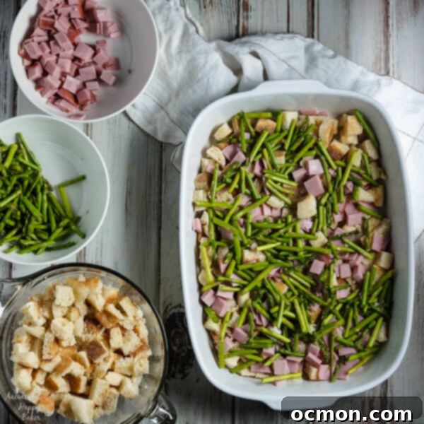 Spring Ham and Asparagus Bake 5 Layers of English muffins, ham, asparagus and cheese are drenched in eggs, Hollandaise mix and half and half for a hearty breakfast casserole that works great anytime of year. #ham #asparagus #breakfastcasserole #breakfastrecipe #accidentalhappybaker