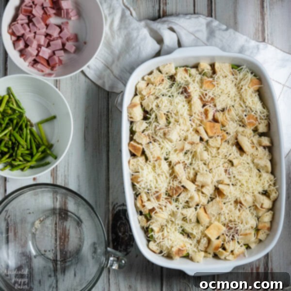 Spring Ham and Asparagus Bake 6 Layers of English muffins, ham, asparagus and cheese are drenched in eggs, Hollandaise mix and half and half for a hearty breakfast casserole that works great anytime of year. #ham #asparagus #breakfastcasserole #breakfastrecipe #accidentalhappybaker