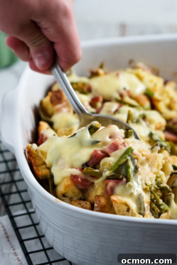 Spring Ham and Asparagus Bake 7 Layers of English muffins, ham, asparagus and cheese are drenched in eggs, Hollandaise mix and half and half for a hearty breakfast casserole that works great anytime of year. #ham #asparagus #breakfastcasserole #breakfastrecipe #accidentalhappybaker