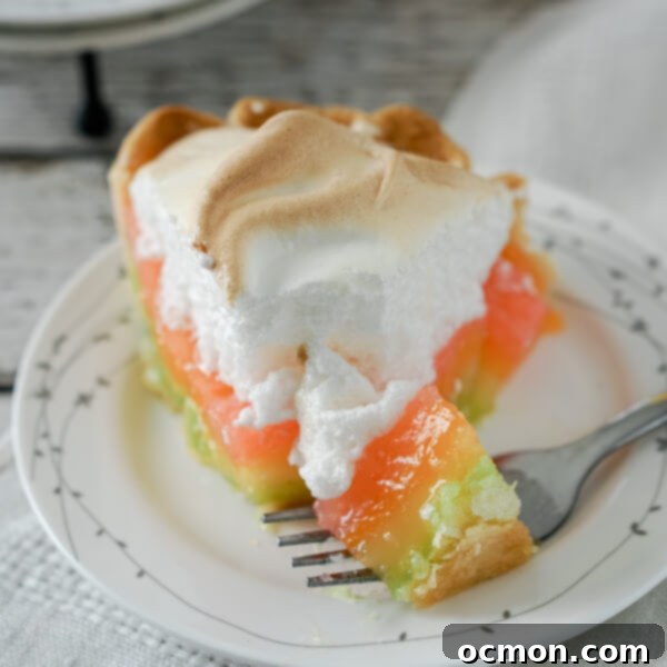 Pastel Peaks of Lemon Sunshine 7 A bite of rainbow lemon meringue pie rests on a fork, showing the layers of colored filling.