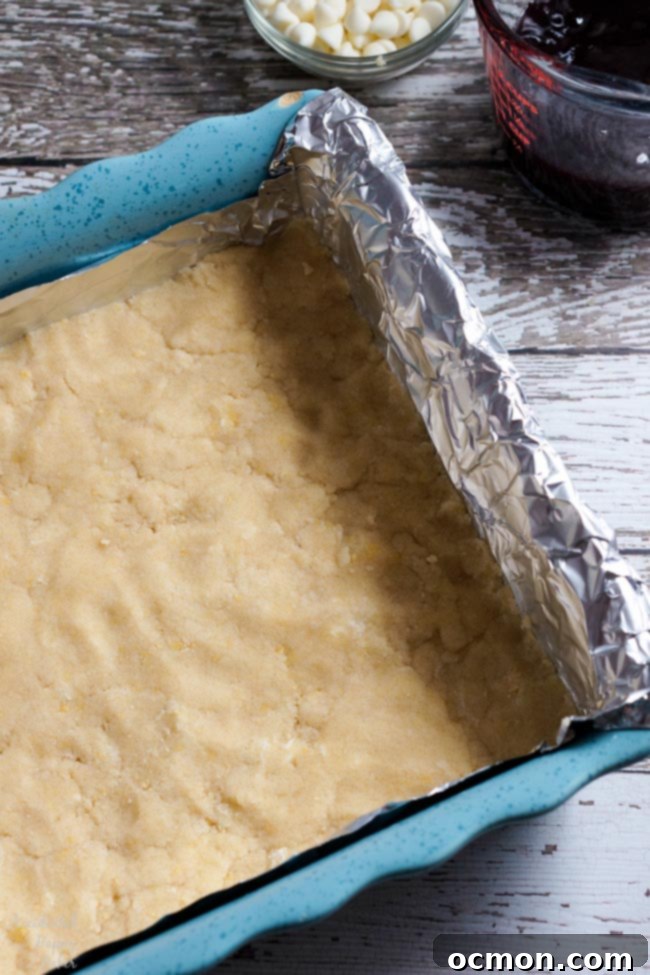 Raspberry White Chocolate Shortbread Bars 3 First a layer of shortbread dough is pressed into a foil lined pan.