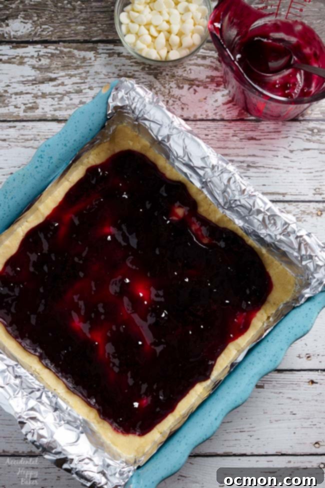 Raspberry White Chocolate Shortbread Bars 4 Next spread the raspberry jam over the shortbread cookie dough.