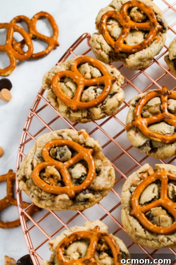 Peanut Butter Pretzel Chocolate Chip Perfection 3 Peanut Butter Pretzel Chocolate Chip Cookies are set out on a cooling rack, perfectly golden and studded with delightful mix-ins.