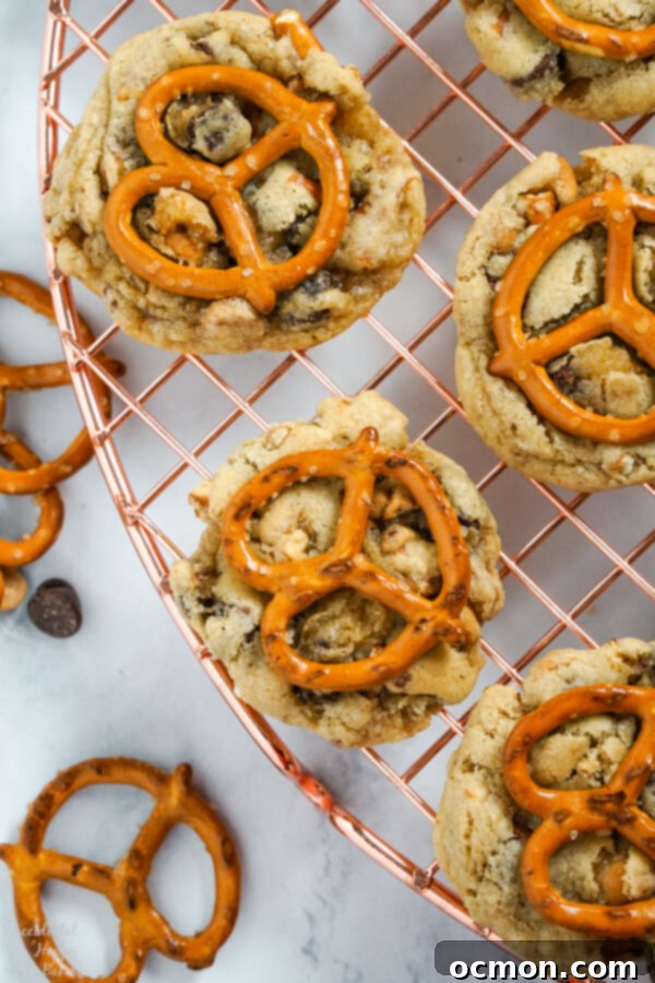 Peanut Butter Pretzel Chocolate Chip Perfection 5 Freshly baked Peanut Butter Pretzel Chocolate Chip Cookies cooling on a wire rack, ready to be enjoyed.