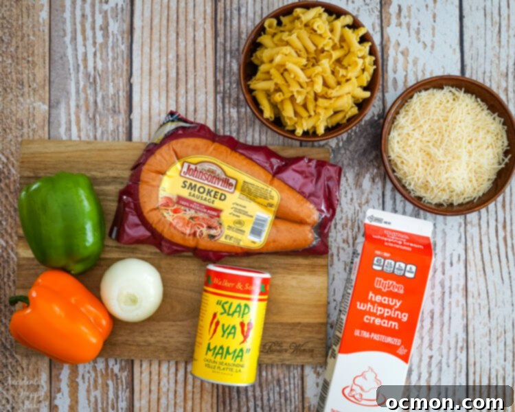 Cajun Kick Alfredo 4 A flat lay of fresh ingredients for Cajun Sausage Alfredo: pasta, grated Parmesan cheese, vibrant bell peppers, sliced smoked sausage, a whole onion, and a bottle of Cajun seasoning.