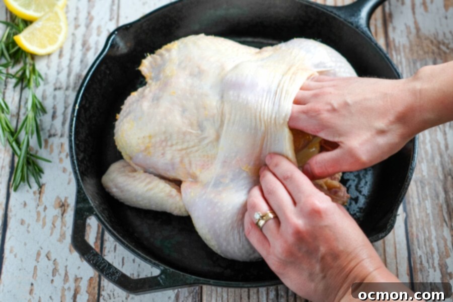 Golden Roast Chicken 6 Hand gently separating chicken skin from the meat, ready for seasoning.