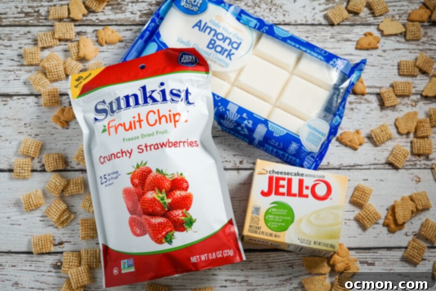 Freeze dried strawberries, almond bark and cheesecake pudding on a wood background with cereal sprinkled around it. 