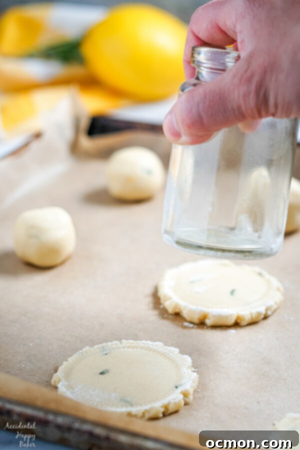 Raw Lemon Rosemary Cookie dough balls on a baking sheet, simple fresh flavors of lemons and rosemary meld together in these buttery shortbread cookies to make an unassuming cookie with a dynamic flavor combination.