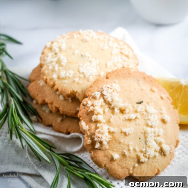 Finished Lemon Rosemary Cookies cooling on a wire rack, simple fresh flavors of lemons and rosemary meld together in these buttery shortbread cookies to make an unassuming cookie with a dynamic flavor combination.