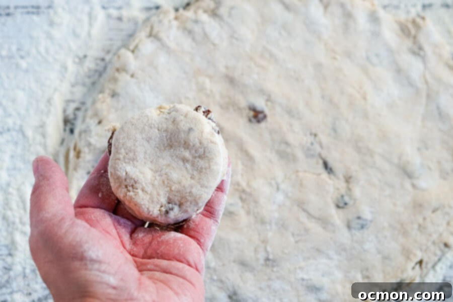 Delightful Cinnamon Raisin Biscuits 6 A mixing bowl with biscuit dough and heavy cream being added.