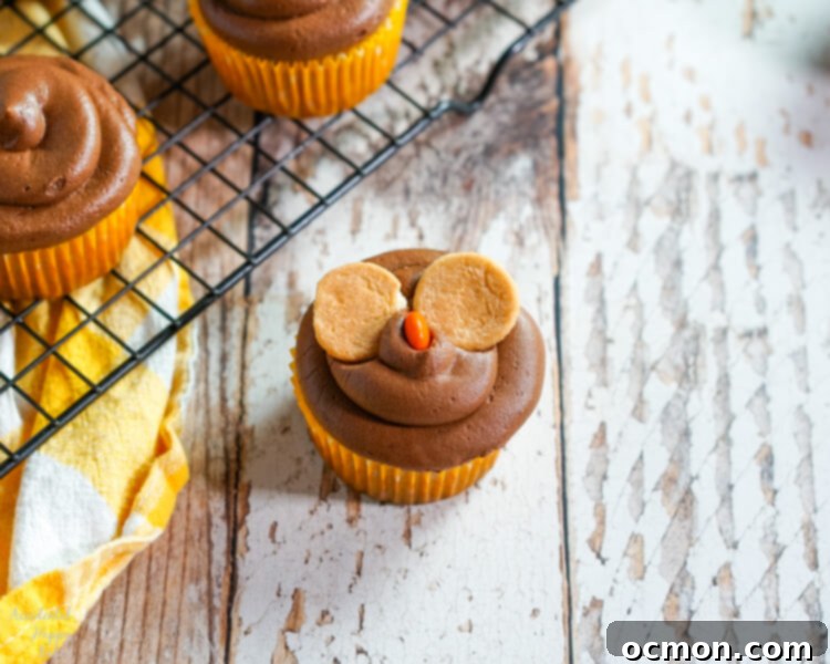 Hoot-Worthy Peanut Butter Chocolate Cupcakes 7 Mini Nilla wafers positioned on a frosted cupcake, forming the base for the owl's eyes.