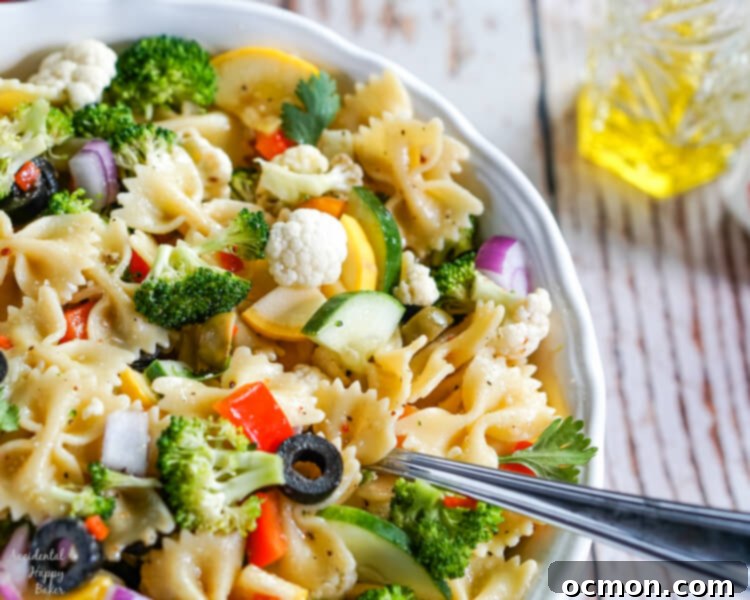Vibrant Summer Veggie Pasta 2 A vibrant bowl of Summer Vegetable Pasta Salad featuring farfalle pasta and a colorful mix of fresh summer vegetables, all coated in a zesty Italian dressing.