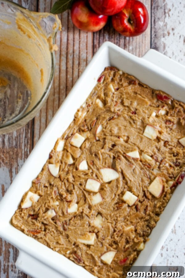 A stack of three apple cinnamon bars, showing the thick, gooey texture and generous chunks of apple and pecans.