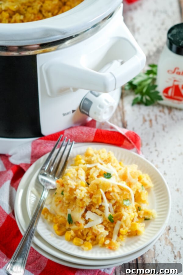 Creamy Slow Cooker Corn Bake 2 Creamy Crock Pot Corn Casserole served with a spoon in a white bowl, showing its texture and ingredients.