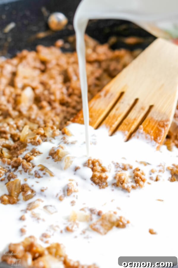 Milk is poured into the ground beef mixture. 