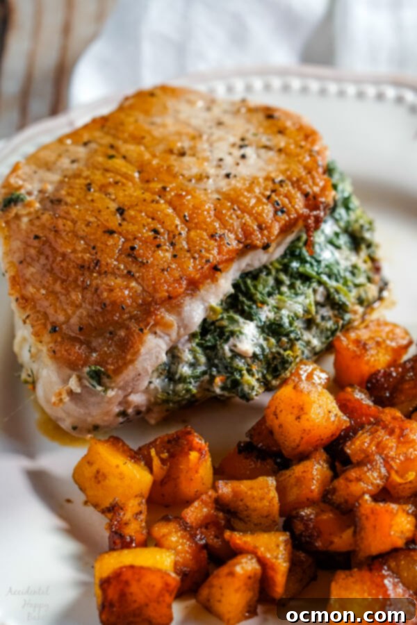 Golden-browned spinach stuffed pork chop on a plate, showcasing the creamy filling