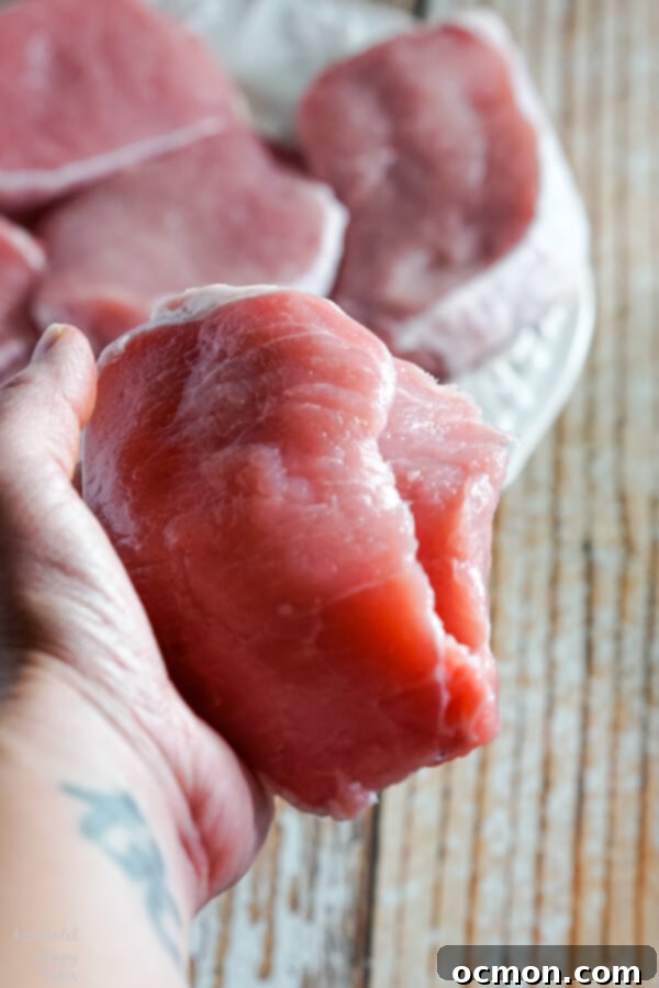 Savory Spinach-Filled Pork Chops 5 Hand using a sharp knife to carefully cut a pocket into a boneless pork chop