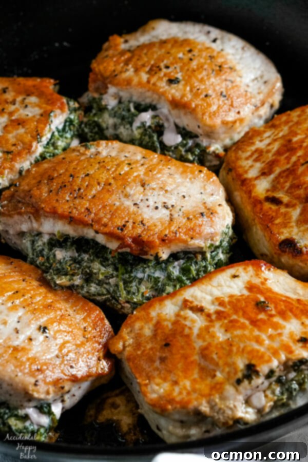 Savory Spinach-Filled Pork Chops 7 Spinach and cheese filling being carefully spooned into the pocket of a raw pork chop