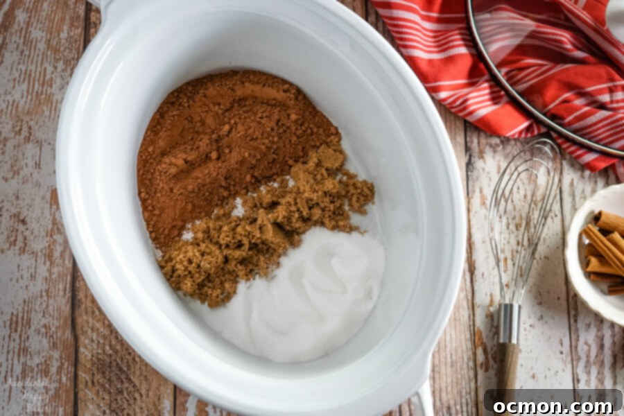 Rich & Spicy Slow Cooker Mexican Hot Cocoa 4 An open white slow cooker surrounded by essential ingredients for Mexican Hot Cocoa: rich cocoa powder, dark brown sugar, and sparkling granulated sugar, alongside a whisk, ready for mixing.