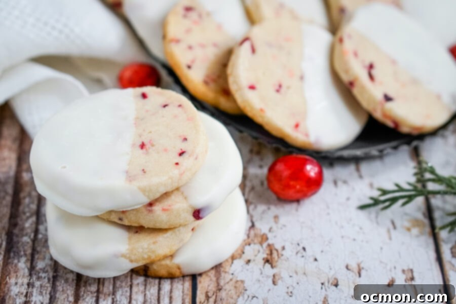 A stack of shortbread cookies next to a plate of cookies. 