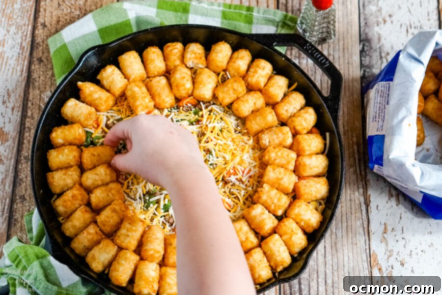 Crispy Tater Tot Shepherds Pie 6 A layer of shredded cheddar cheese is added before finishing the casserole with a layer of frozen tater tots for Shepherd's Pie with Tater Tots.