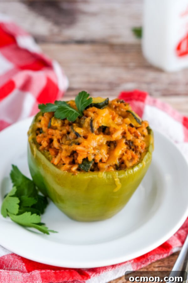 Colorful wild rice stuffed bell peppers arranged on a platter, showcasing the golden-brown sausage and rice filling inside vibrant red and yellow peppers.