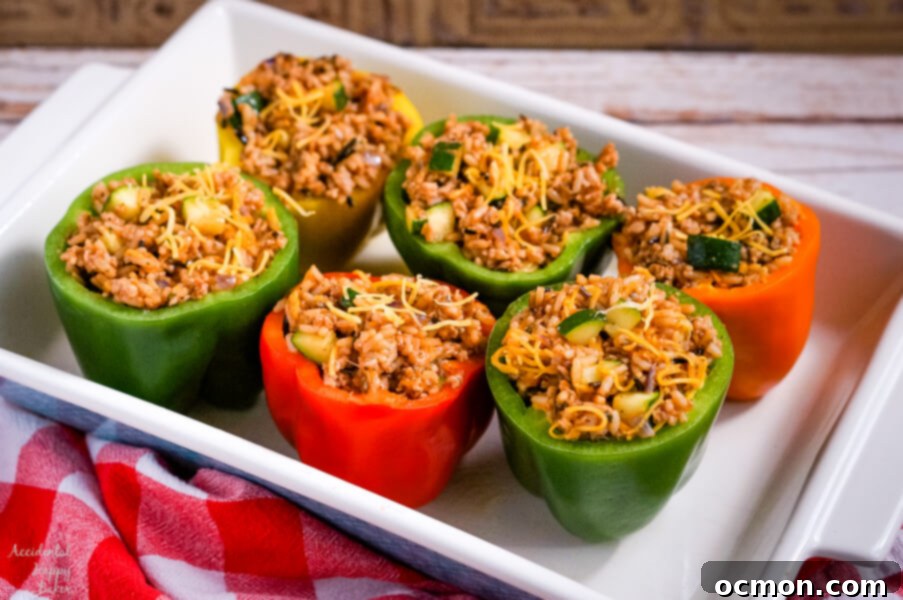 Prepared bell peppers with tops sliced off and seeds removed, ready for stuffing, arranged neatly in a baking dish.