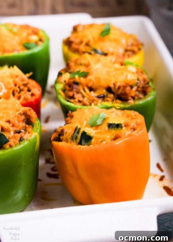 Baked wild rice stuffed bell peppers topped with melted cheddar cheese, ready to be served hot.