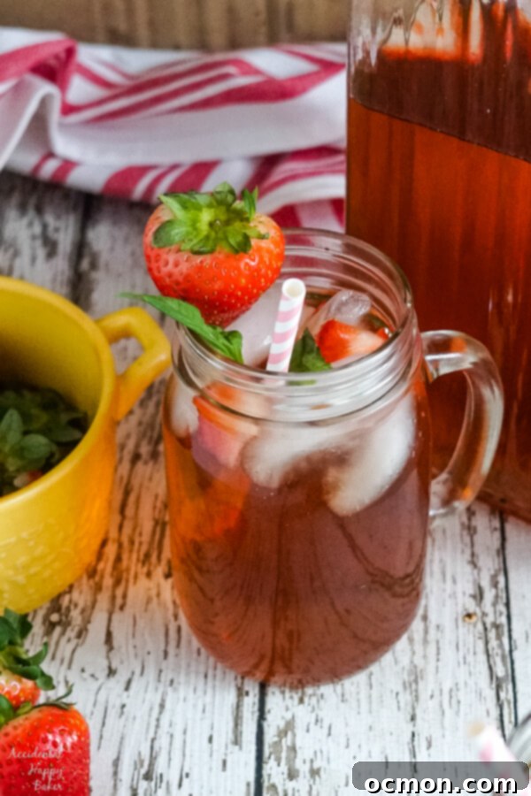 Crimson Basil Cooler 2 Refreshing Strawberry Basil Iced Tea in a mason jar, served alongside a full pitcher, perfect for summer.