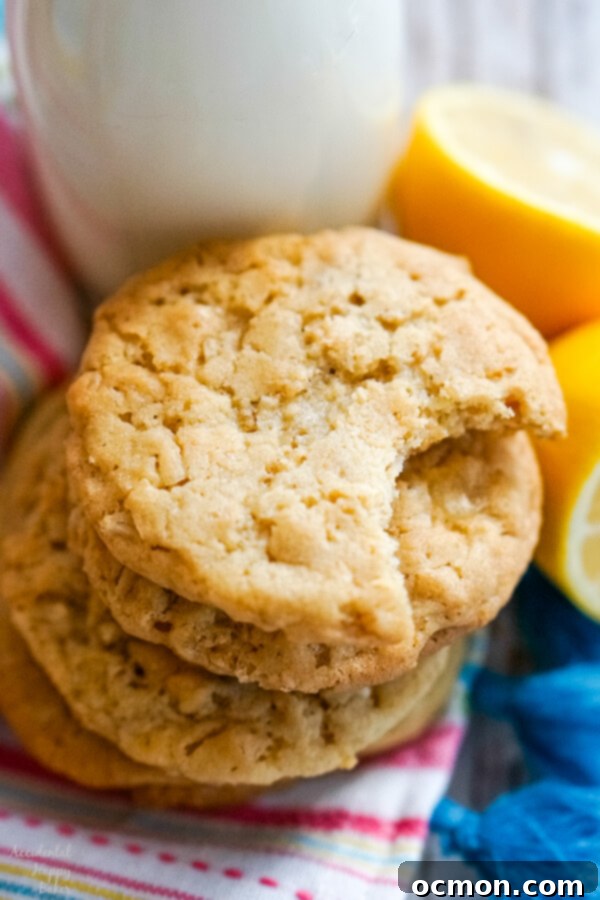 Zesty Lemon Cowboy Cookies 2 A stack of lemon cowboy cookies next to a bottle of milk, highlighting their golden edges and soft centers.