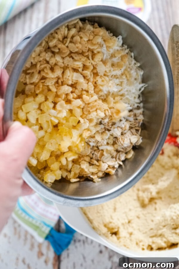 Zesty Lemon Cowboy Cookies 4 The process of adding the vibrant candied lemon peel, oats, coconut, and crispy rice cereal to a bowl of freshly mixed cookie dough.
