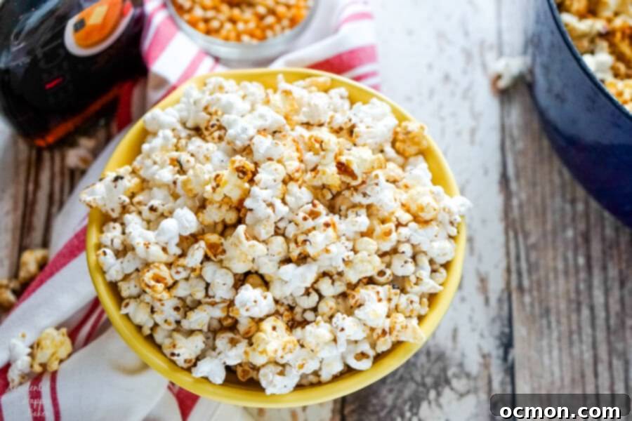 A yellow bowl full of dutch oven kettle corn sitting next to a blue dutch oven. 
