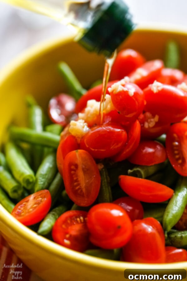 Savory Green Bean and Tomato Bake 5 A close up showing olive oil drizzled over the vegetables.