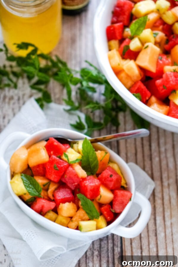 Summer Watermelon Bliss 6 A serving of fruit salad in a small white bowl with several sprigs of fresh mint to the side.