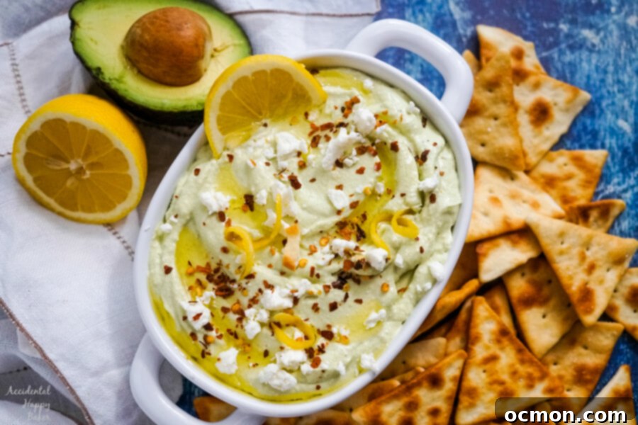 Bright Lemon Feta Dip 6 A white serving bowl of lemon feta dip surrounded by pita chips.