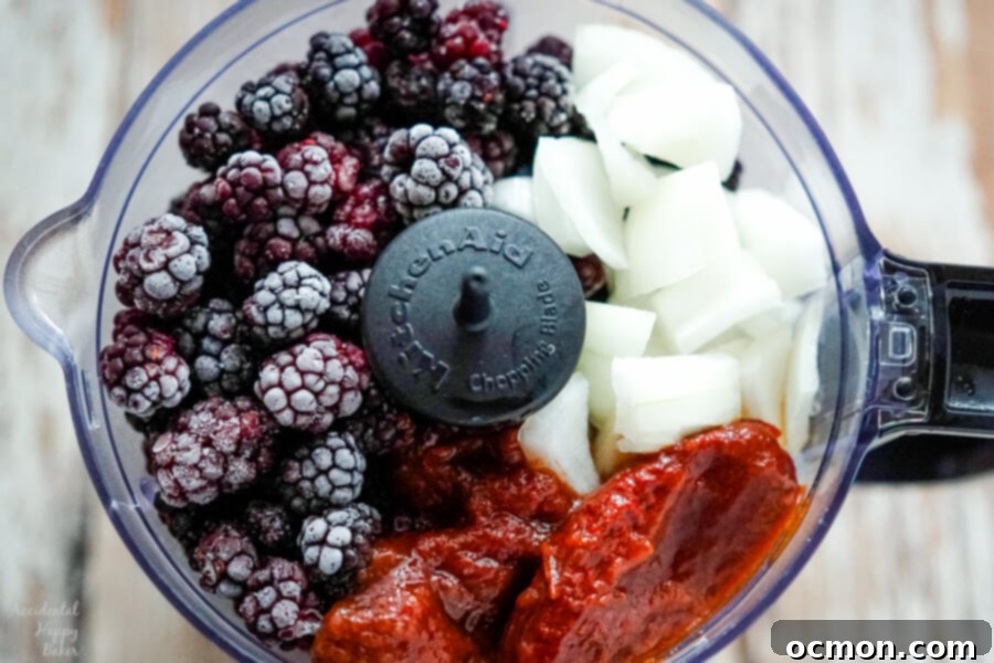 Blackberries, onion, and chipotle peppers are added to the food processor.