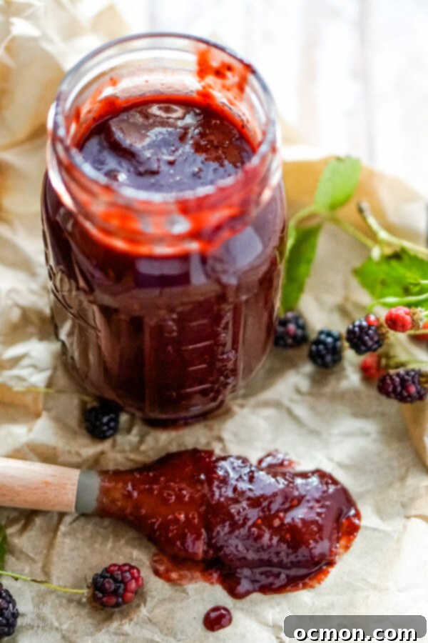 A jar of blackberry bbq sauce with a basting brush to one side.