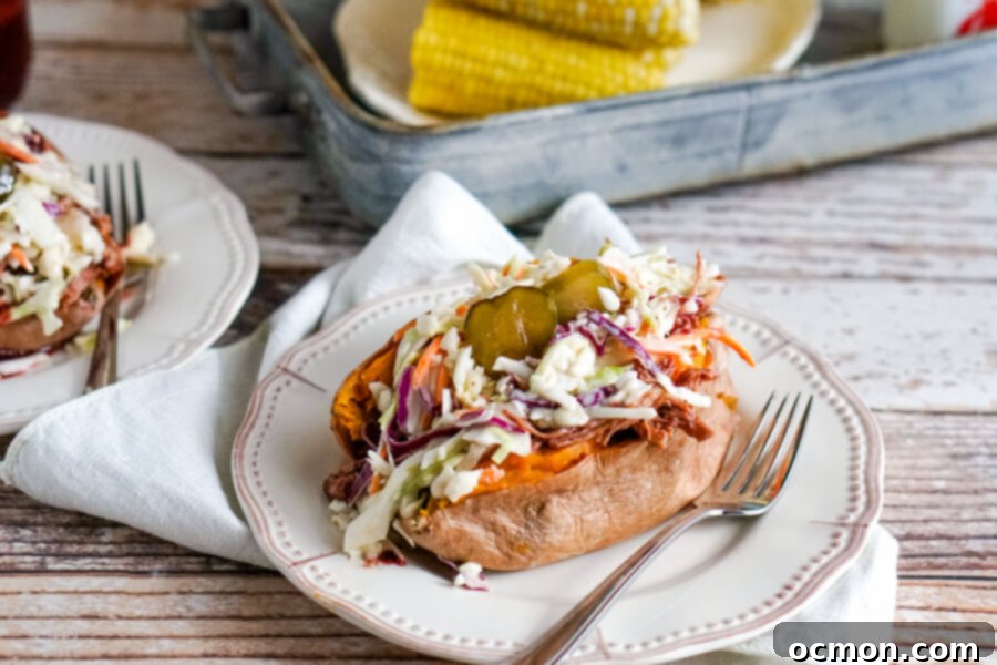 Two stuffed sweet potatoes on white plates next to a tray with corn on the cob. 