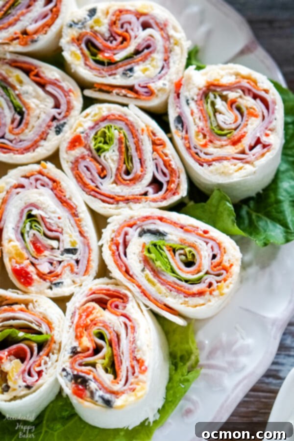 Irresistible Italian Twists 3 A close-up of a partially rolled Italian Pinwheel tortilla, showing layers of cream cheese spread, cheese, salami, pepperoni, ham, and fresh romaine lettuce.