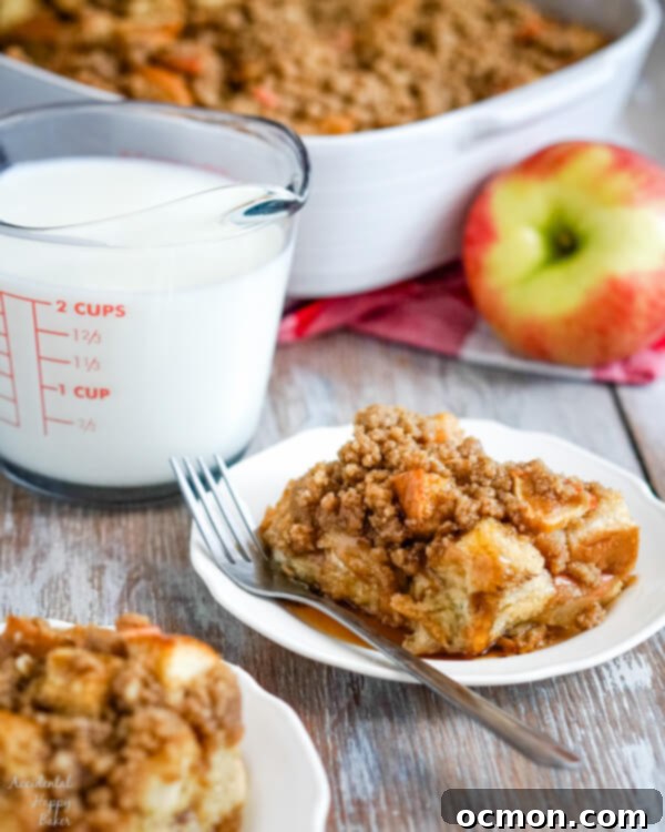 Warm Cinnamon Apple French Toast Bake 2 Two servings of Cinnamon Apple French Toast Casserole on white plates with a measuring cup of milk to the side.