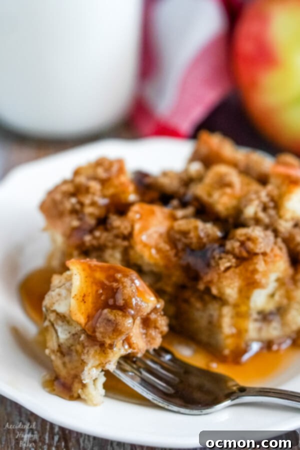 Warm Cinnamon Apple French Toast Bake 3 A close up image of a bite of french toast casserole dripping with syrup.