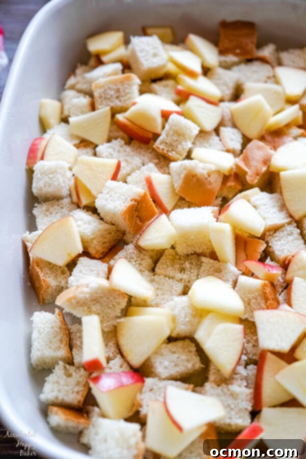Warm Cinnamon Apple French Toast Bake 6 Bread cubes and chopped apples are layered in a 9x13 pan.